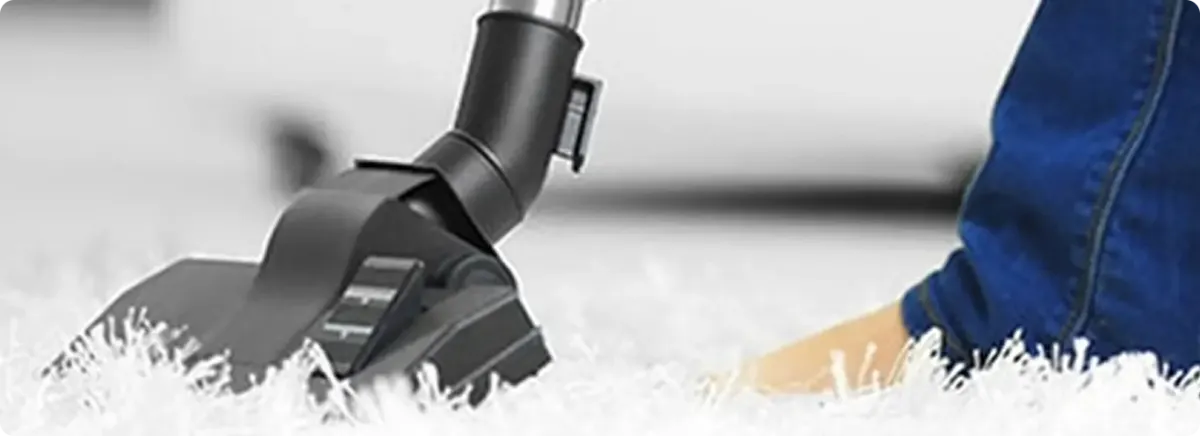 Close-up of a professional vacuuming a white carpet in Madison.